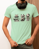 A man wearing a green t-shirt with a graphic design of three cartoonish statues of a cat, a bird, and a temple.